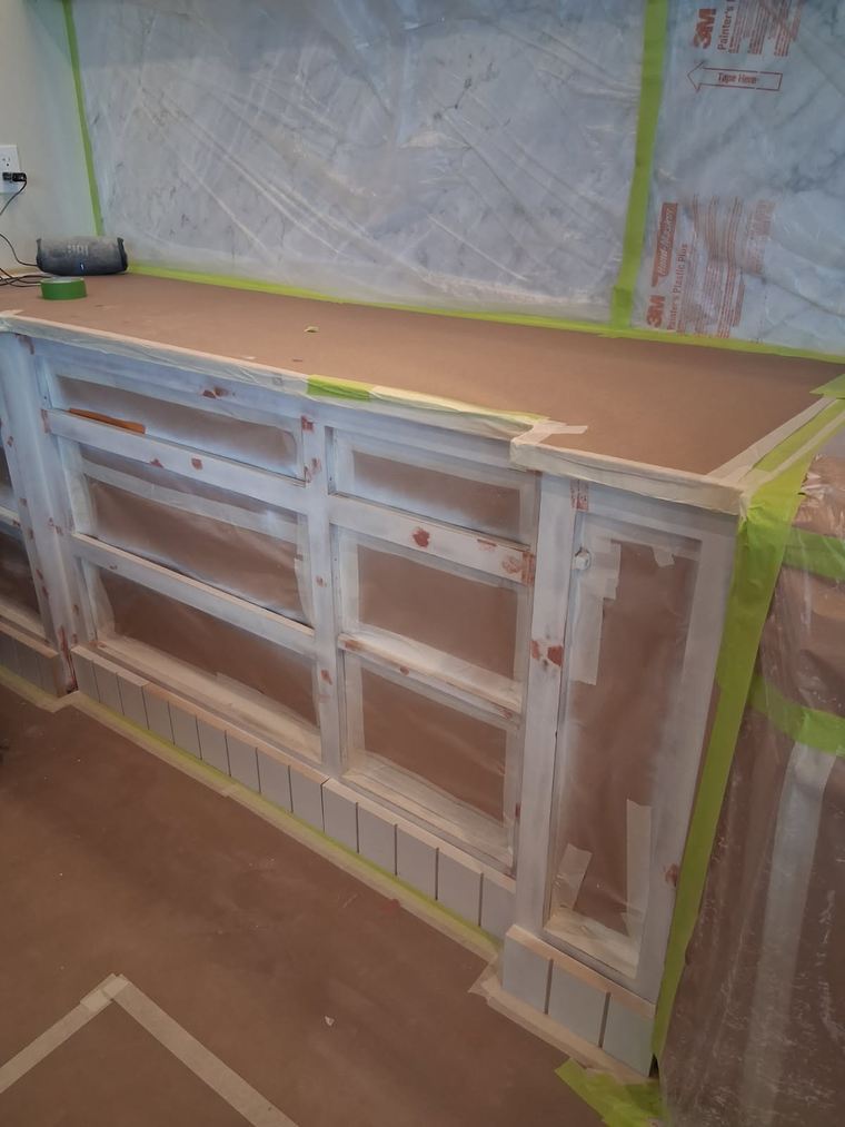 Kitchen cabinets masked and primed during refinishing